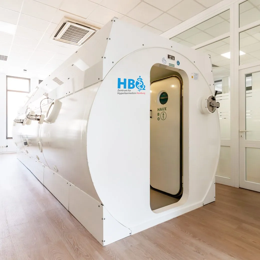 Mehrplatz-Druckkammer mit geöffneter Tür in einem hellen Behandlungsraum, Zentrum für Hyperbarmedizin Hamburg